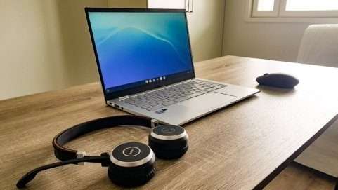 Laptop on a desk with headphones used for sound only therapy